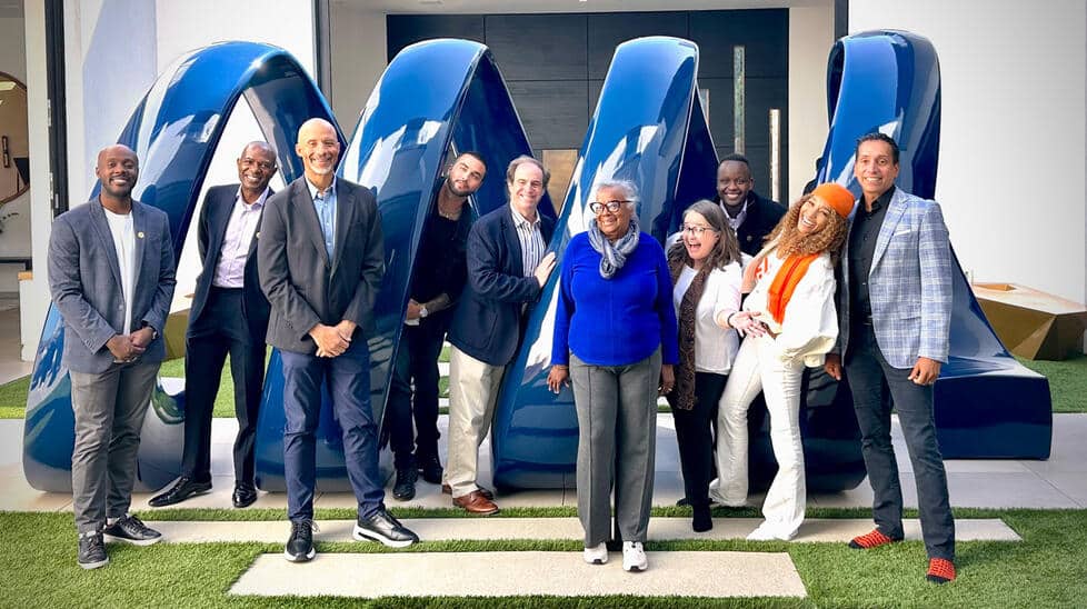PAW writer Mark. F. Bernstein '83 with alumni who work with Kwanza Jones ’93 and José E. Feliciano ’94 standing in front of a statue at their Pacific Palisades home.Courtesy of Kwanza Jones ’93 and José E. Feliciano ’94